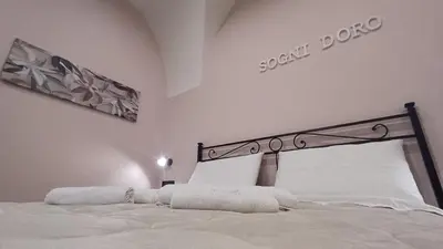 a bedroom with a white bed with a sign on the wall at Sogni D'oro 01 in Partinico