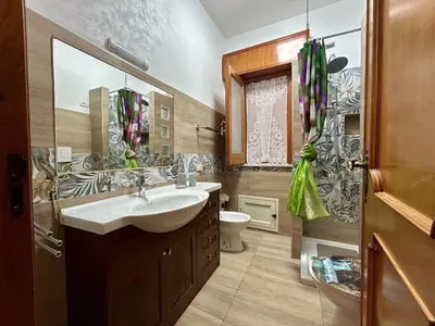 a kitchen with white cabinets and a table in it at Casa Albachiara in Borgetto