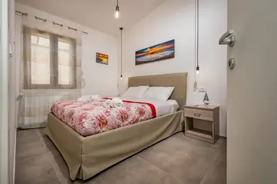 a bedroom with a large bed and a window at Villa Paradise Luxury in Castellammare del Golfo