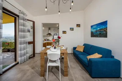 a dining room with a table and a blue couch at Villa Paradise Luxury in Castellammare del Golfo