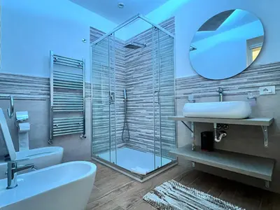 a bathroom with a shower and a sink and a mirror at INFINITY Luxury Apartment in Palermo