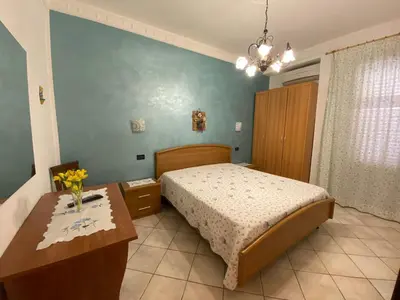 a bedroom with a bed and a table with flowers on it at Le Ortensie Appartamento Grande in San Vito lo Capo