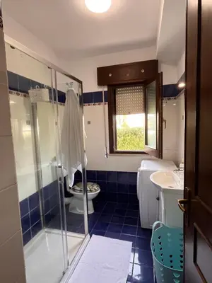 a bedroom with a large bed with a blue headboard at A Casa Da Mari' in Terrasini