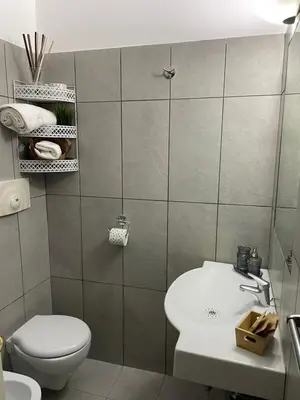 a bathroom with a white toilet and a sink at Appartamento Ciccio al Capo in Palermo