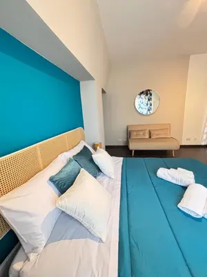 a bedroom with a blue wall and a bed with pillows at Maison N 16 in Palermo