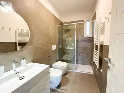 a bathroom with a toilet and a shower and a sink at Le Case del Massimo in centrocittà in Palermo