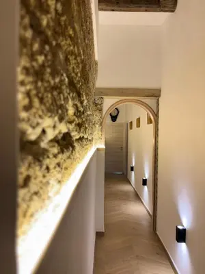 a hallway with a stone wall and an archway at Palermo Sunset in Palermo