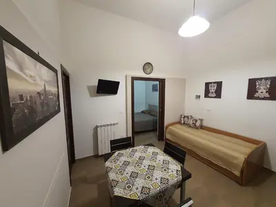 a bedroom with a bed and a table and a clock at Casa Vacanza Isola di Eufemio Piano Terra in Capaci