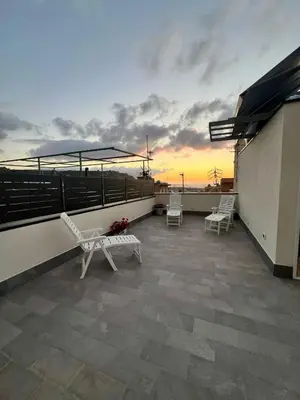 a balcony with chairs and a sunset on a roof at La Casetta di Sa Lu in Capaci