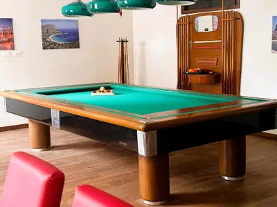 a pool table in a room with two chairs at Gira e Firria in Palermo