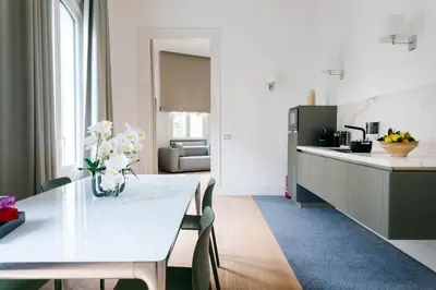 a kitchen and dining room with a white table and chairs at G Cave 125 Boutique Apartment in Palermo