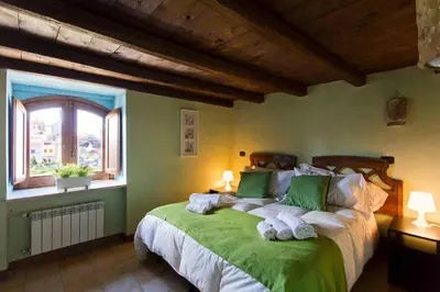 a bedroom with a large green bed with towels on it at Vela House charming front of sea in Palermo