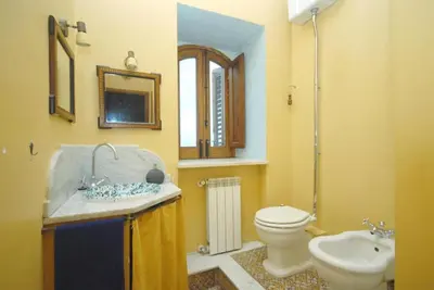 a bathroom with a sink and a toilet and a mirror at Vela House charming front of sea in Palermo