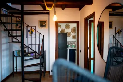 a room with a spiral staircase and a refrigerator at Vela House charming front of sea in Palermo