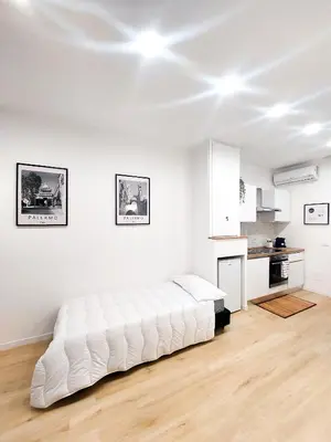a large white bed in a room with a kitchen at Da Vera Apartment in Palermo