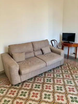 a brown couch in a living room with a table at La Casa di Alan in Palermo