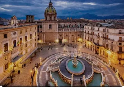 a large building with a fountain in a courtyard at La casa di gabry in Palermo