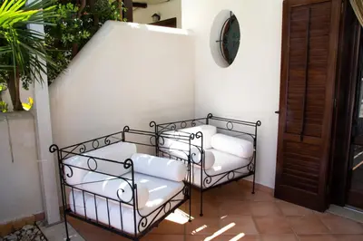a pair of white chairs sitting on a porch at Anemos Apartment - Villa Luna in Macari