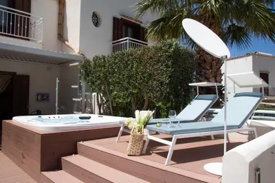 a jacuzzi tub with two chairs and a table at Anemos Apartment - Villa Luna in Macari