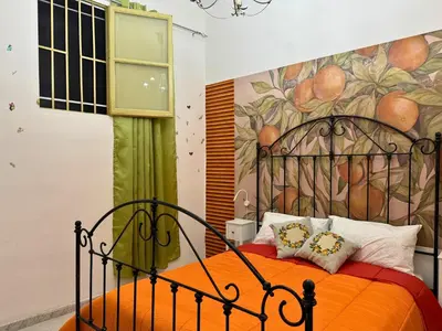 a bedroom with an orange bed with a painting on the wall at Orange Lemon Business Palermo in Palermo