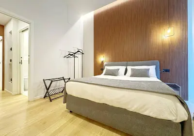 a bedroom with a large bed and a wooden wall at Solemar Sicilia - Design Apartment Palermo in Palermo