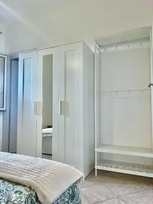 a bedroom with white cabinets and a bed in it at La Terrazza del Mare in Palermo