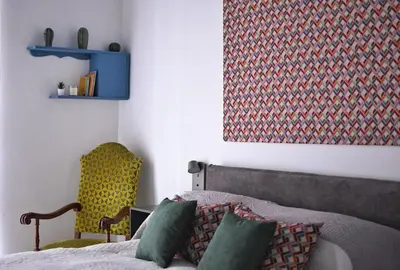 a bedroom with a bed and a yellow chair at iFlat Un balcone in Cattedrale in Palermo
