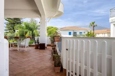 a patio with a white fence and a table and chairs at More Holidays Sun in Mondello