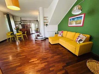 a living room with a yellow couch and a green wall at More Holidays Sun in Mondello
