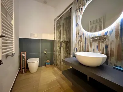 a bathroom with a large white sink and a mirror at Paternostro Luxury Apartment in Palermo