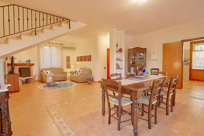 a large living room with a table and chairs at Villa Cottone - 5 suite con piscina privata - tra Palermo e Cefalù in Altavilla Milicia