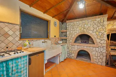 a kitchen with a large stone oven in a room at Villa Cottone - 5 suite con piscina privata - tra Palermo e Cefalù in Altavilla Milicia