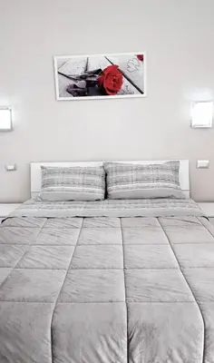 a white bedroom with a large bed and a picture on the wall at Tourist House Palermo in Palermo