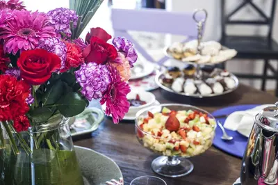 a table with a vase of flowers and plates of food at BB 22 Palace in Palermo