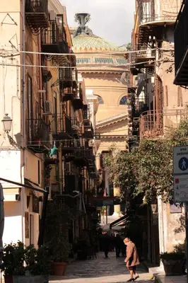 a person walking down a street with a building at B&B Teatro in Palermo
