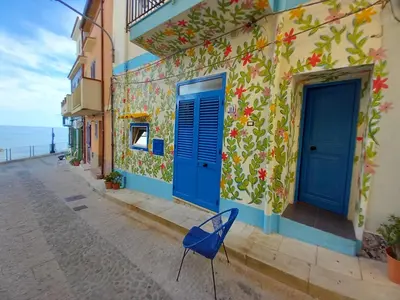 a blue chair sitting on a street next to a building at Casa Vacanze Marco Polo vista mare in Trappeto