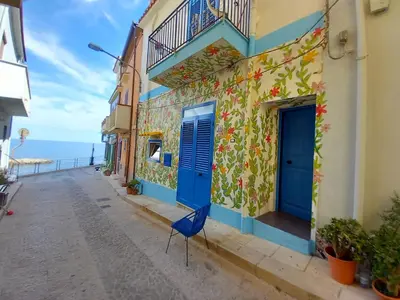 a blue door on a building with the ocean in the background at Casa Vacanze Marco Polo vista mare in Trappeto