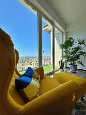 a living room with a yellow couch and a large window at The Best View Sicily Apart in Carini