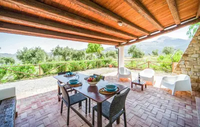 a table and chairs on a patio with a view at Nice Apartment In Collesano Pa in Lascari