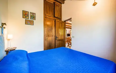 a bedroom with a blue bed and a wooden cabinet at Amazing Apartment In Collesano Pa in Lascari