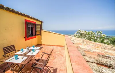 a patio with a table and chairs on top of a building at Stunning Apartment In Collesano Pa in Lascari