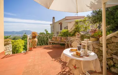 a patio with a table and an umbrella at Nice Apartment In Palermo in Palermo