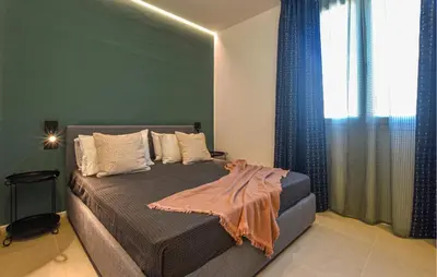 a bedroom with a bed with a green wall at Stunning Apartment In Trappeto in Trappeto