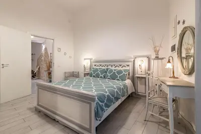 a bedroom with a bed and a table and a mirror at GuestHost - Castrum Lodge - Ballarò Stylish Apartment in Palermo