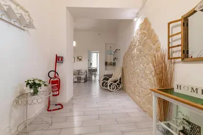 a hallway with a large stone wall and a table at GuestHost - Castrum Lodge - Ballarò Stylish Apartment in Palermo