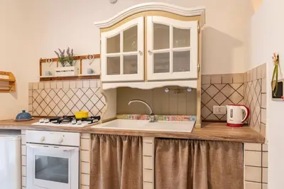 a kitchen with white cabinets and a sink at GuestHost - Castrum Lodge - Ballarò Stylish Apartment in Palermo