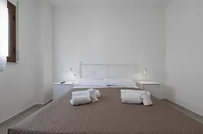 a bedroom with a bed and a couch and a television at Appartamenti Via Meli in Balestrate