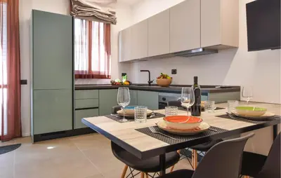 a kitchen with a table with chairs and wine glasses at Stunning Apartment In Trappeto With Wifi in Trappeto