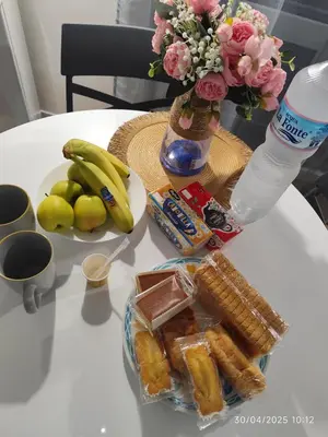 a table with a plate of pastries and a vase of flowers at Palermo Centro Gaale in Palermo