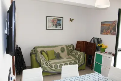 a living room with a couch and a chair at Cento Pini Holiday Cefalù in Buonfornello